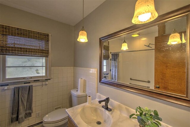 full bath with tile walls, toilet, vanity, a shower with curtain, and wainscoting