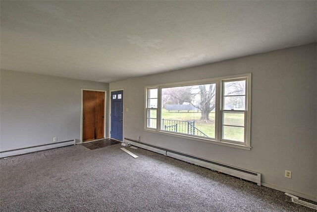 spare room with carpet floors, a baseboard heating unit, and baseboard heating