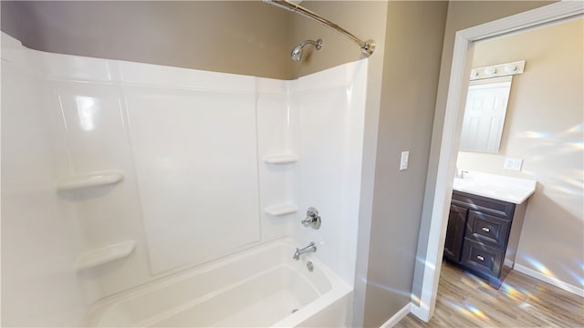 full bath with vanity, wood finished floors, baseboards, and shower / bathtub combination