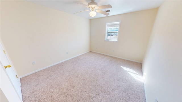 carpeted empty room with baseboards, visible vents, and ceiling fan