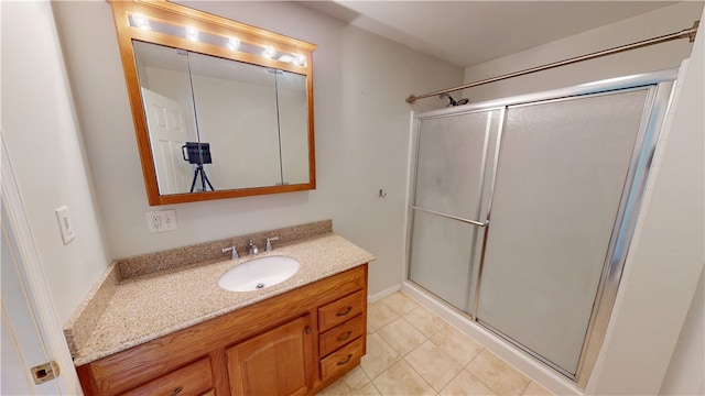 bathroom with tile patterned flooring, a shower stall, and vanity