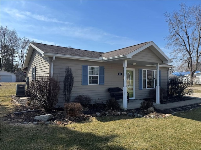 view of front facade featuring a porch, central AC, a front lawn, and a shingled roof