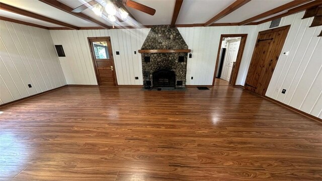 3728 N Lake Blvd, Danville, IL 61832 - unfurnished living room with beamed ceiling, wood finished floors, a ceiling fan, and a stone fireplace