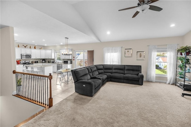 living area featuring light colored carpet, ceiling fan with notable chandelier, recessed lighting, light tile patterned floors, and lofted ceiling