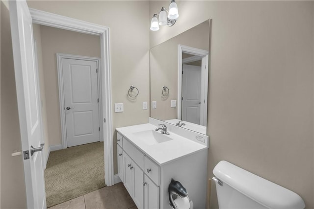 half bath with vanity, baseboards, tile patterned flooring, and toilet