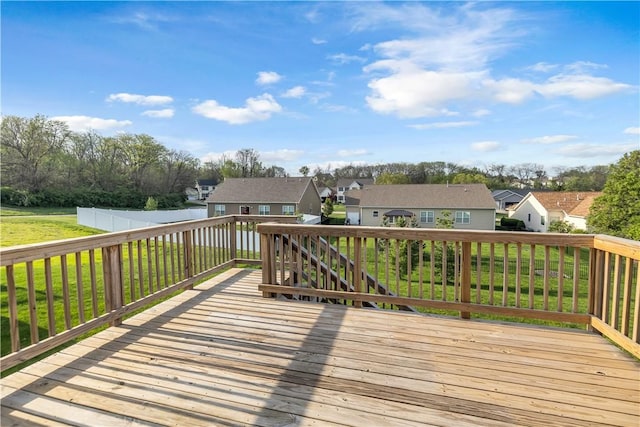 wooden deck featuring a residential view and a yard