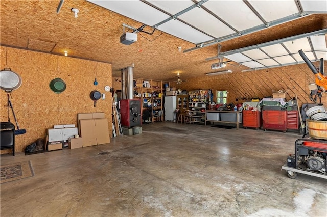 garage featuring white refrigerator, a garage door opener, and a workshop area