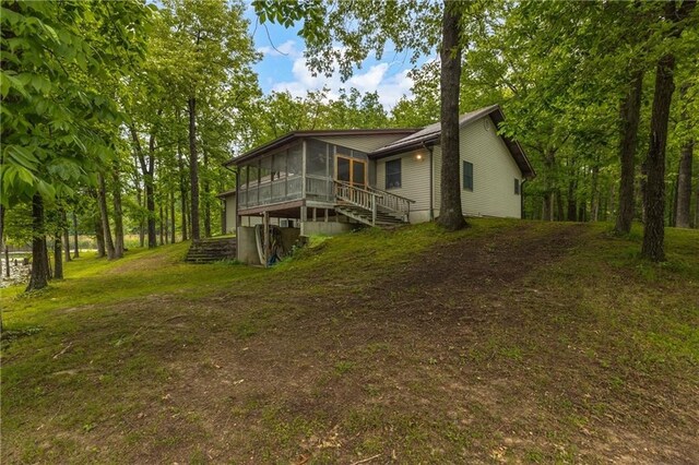 rear view of house with a yard and a sunroom