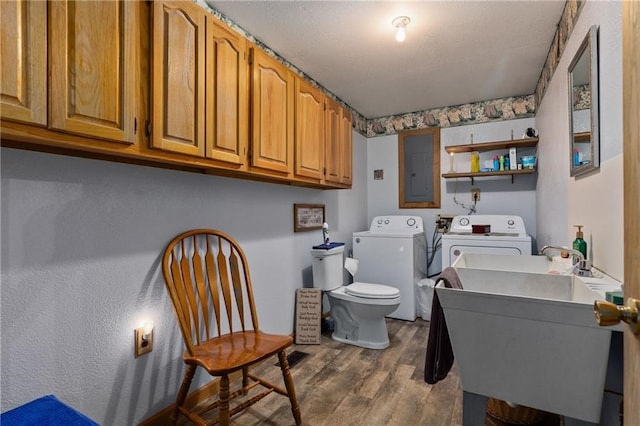 washroom featuring sink, wood-type flooring, electric panel, and washer and dryer