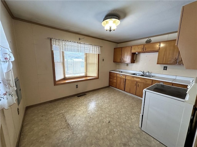 kitchen featuring tile counters, crown molding, stove, and sink