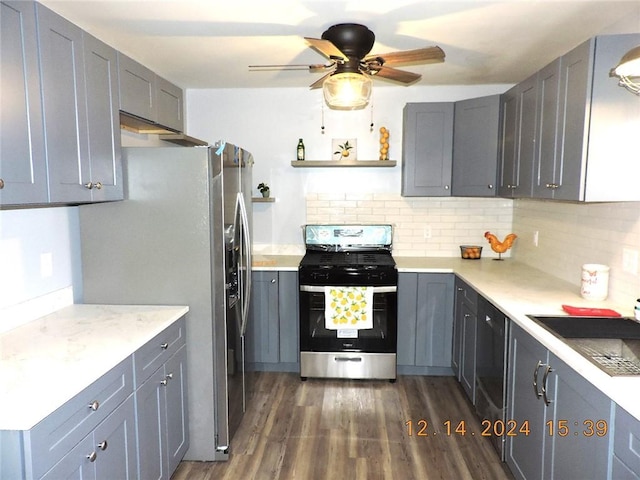 kitchen with appliances with stainless steel finishes, tasteful backsplash, ceiling fan, sink, and dark hardwood / wood-style floors