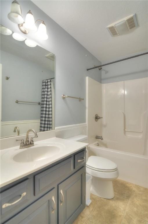 bathroom featuring toilet, vanity, visible vents, tile patterned floors, and shower / bath combination with curtain