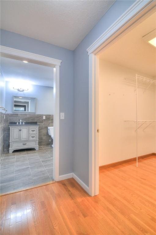 corridor with baseboards and wood finished floors