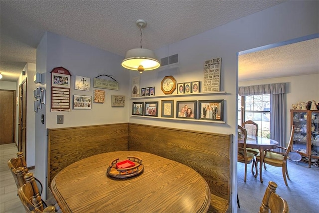 dining space featuring visible vents and a textured ceiling