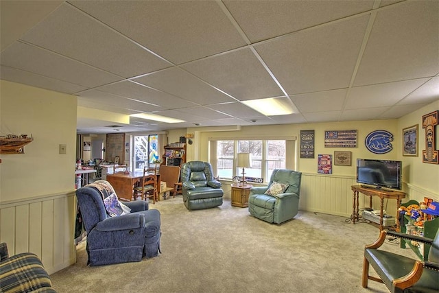 carpeted living room with wainscoting and a paneled ceiling