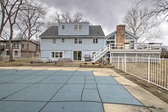 rear view of property with a patio, fence, stairs, a wooden deck, and a fenced in pool