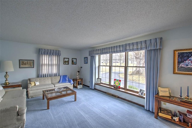 living area with carpet floors, baseboards, and a textured ceiling