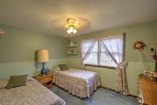 bedroom featuring carpet floors, visible vents, a textured ceiling, and baseboards