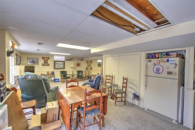 carpeted office space with a paneled ceiling