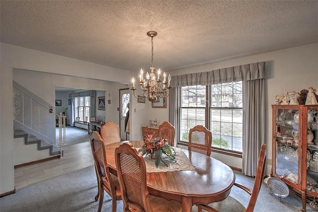 dining room featuring stairway, a textured ceiling, and an inviting chandelier