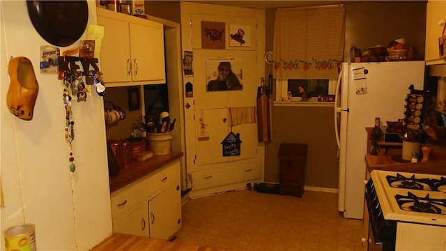 kitchen with white cabinetry and white fridge