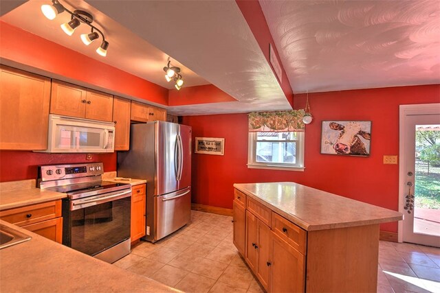 kitchen with hanging light fixtures, light tile patterned flooring, stainless steel appliances, and track lighting