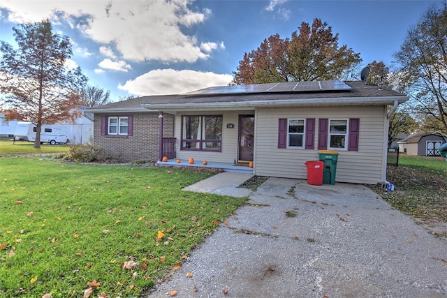 single story home with covered porch, solar panels, and a front lawn