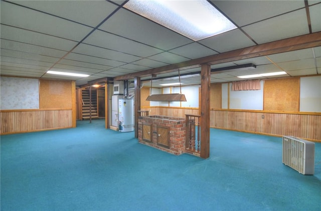 635 E N St, Warrensburg, IL 62573 - finished basement featuring water heater, a paneled ceiling, carpet flooring, wood walls, and a wainscoted wall