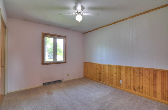 635 E N St, Warrensburg, IL 62573 - carpeted empty room featuring a ceiling fan, wood walls, and baseboard heating