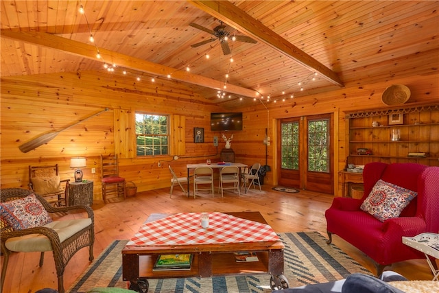 living room with wood ceiling, vaulted ceiling with beams, wood walls, and light hardwood / wood-style floors