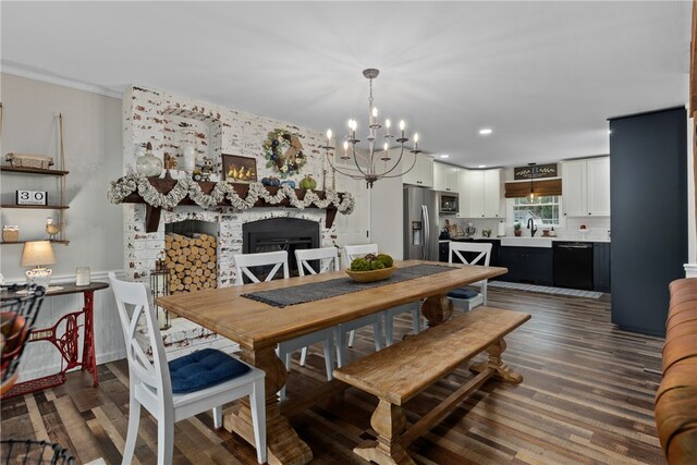 dining area with hardwood / wood-style flooring, sink, and an inviting chandelier