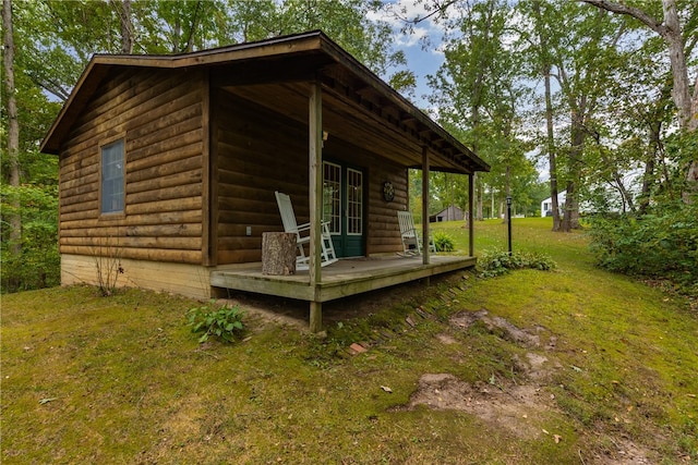 view of side of home with a lawn and covered porch