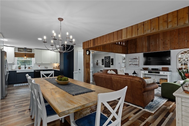 dining room with a chandelier, hardwood / wood-style floors, and sink