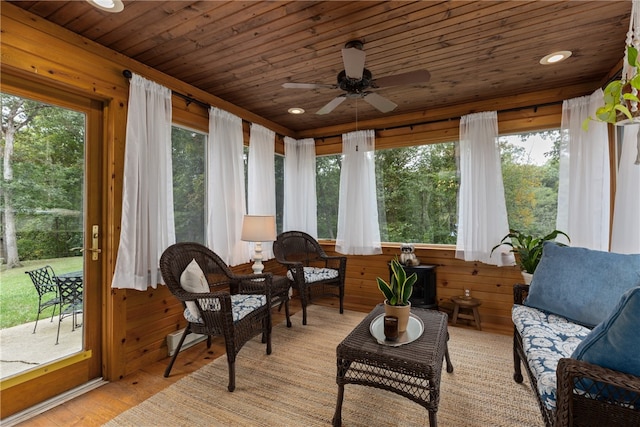 sunroom with ceiling fan, a healthy amount of sunlight, and wooden ceiling