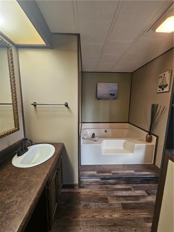 bathroom featuring hardwood / wood-style flooring, vanity, and a bathtub