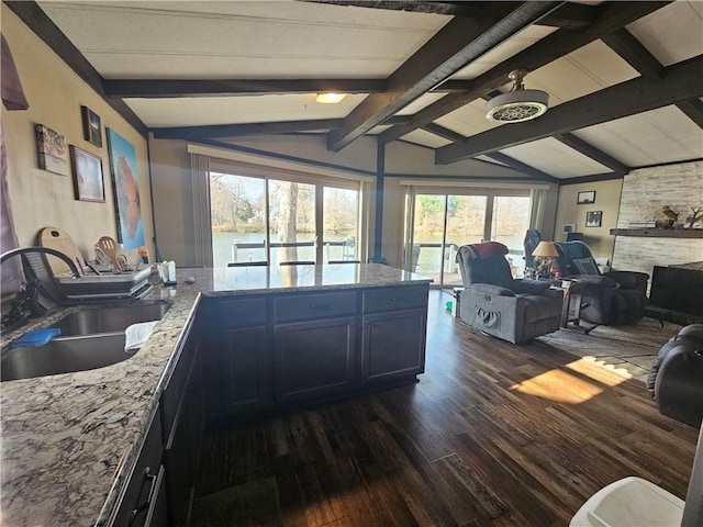 interior space with vaulted ceiling with beams, sink, and dark wood-type flooring