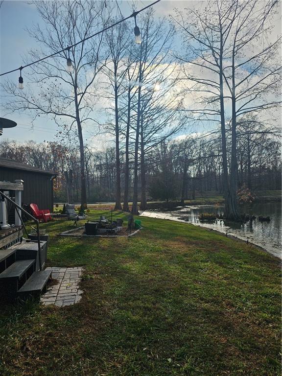 view of yard featuring a water view and a fire pit