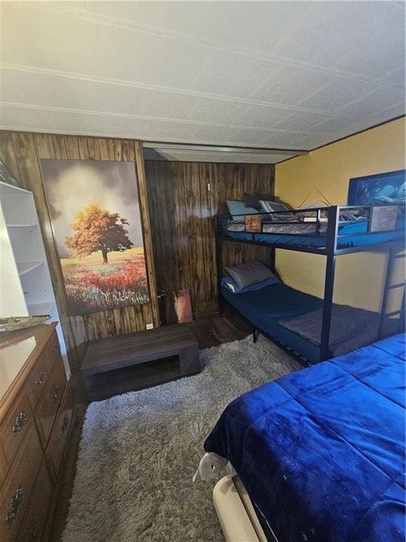 carpeted bedroom with wooden walls