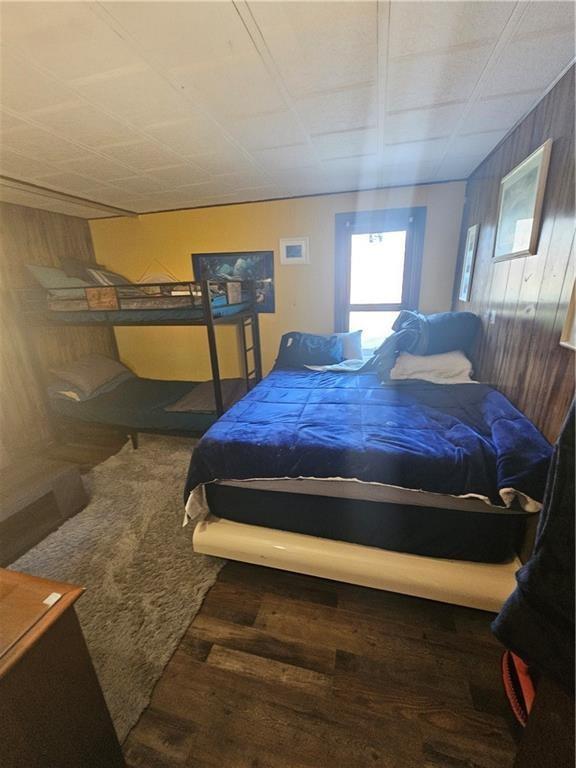 bedroom featuring wood walls