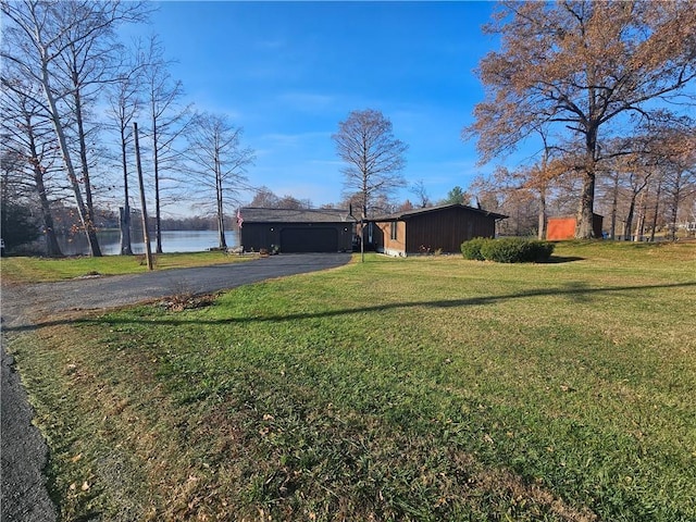 exterior space with a water view, a front yard, and a garage