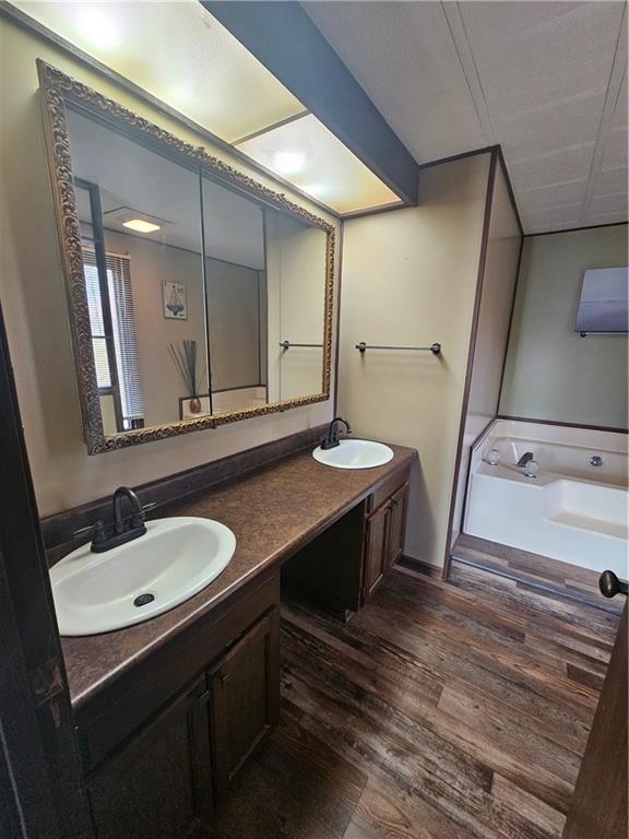 bathroom featuring hardwood / wood-style floors, vanity, and a bathtub