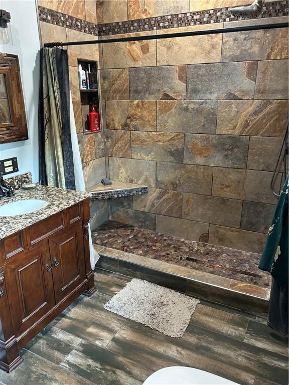 10760 E 1600th St, Cambridge, IL 61238 - bathroom with vanity, a tile shower, and wood finished floors