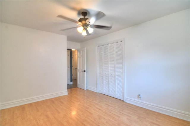 235 W Lawrence St, Illiopolis, IL 62539 - unfurnished bedroom with light wood-style floors, a closet, and a ceiling fan