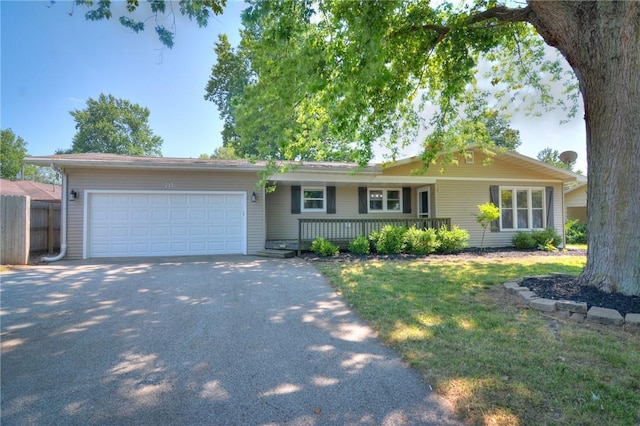 235 W Lawrence St, Illiopolis, IL 62539 - single story home with driveway, an attached garage, a front yard, and a porch