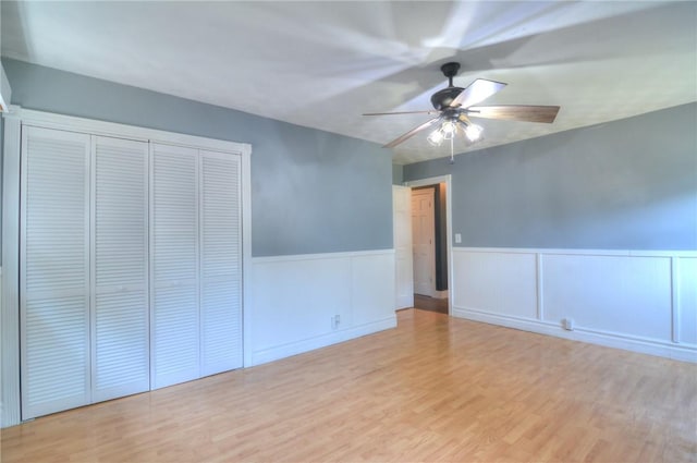 235 W Lawrence St, Illiopolis, IL 62539 - unfurnished bedroom with wainscoting, wood finished floors, a closet, and ceiling fan
