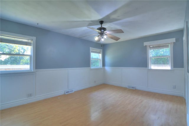 235 W Lawrence St, Illiopolis, IL 62539 - spare room featuring a wainscoted wall, a ceiling fan, and wood finished floors