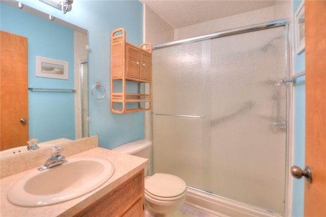 full bathroom featuring vanity, a shower stall, and toilet