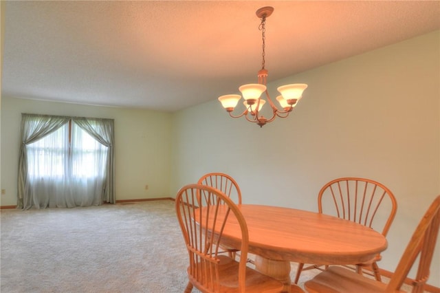 carpeted dining area with a textured ceiling, baseboards, and a notable chandelier