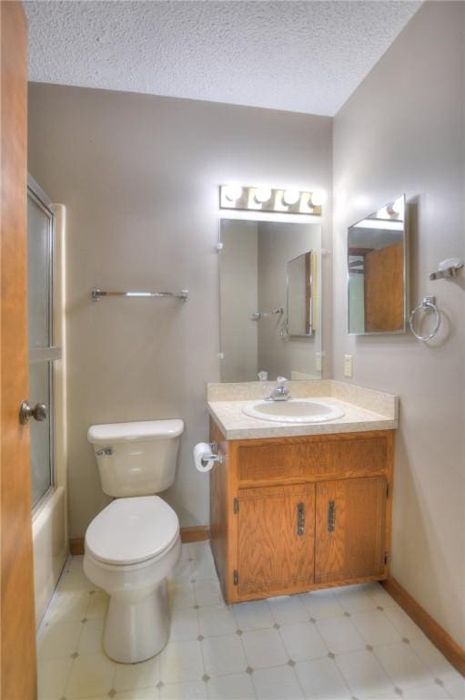 bathroom with a textured ceiling, tile patterned floors, toilet, and vanity
