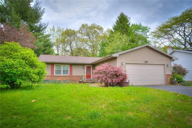 ranch-style home featuring brick siding, an attached garage, a front lawn, and aphalt driveway